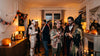 Soirée Halloween entre adultes déguisés dans un salon, citrouilles et bougies